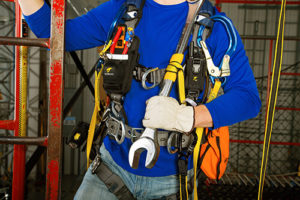 man in harness with tools attached to line